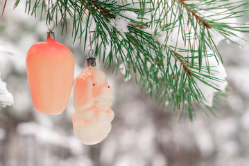 vintage Christmas decorations on a lively fir in snowy winter forest outdoor