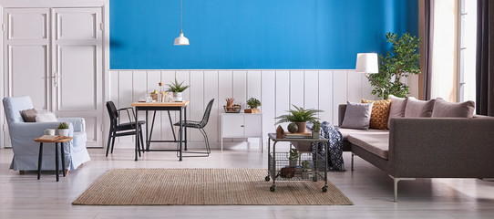 Living room furniture grey sofa blue armchair and dining table wooden detail style. White and blue...