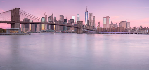 Panorama of downtown Manhattan with Brooklyn bridge from east river at sunrise
