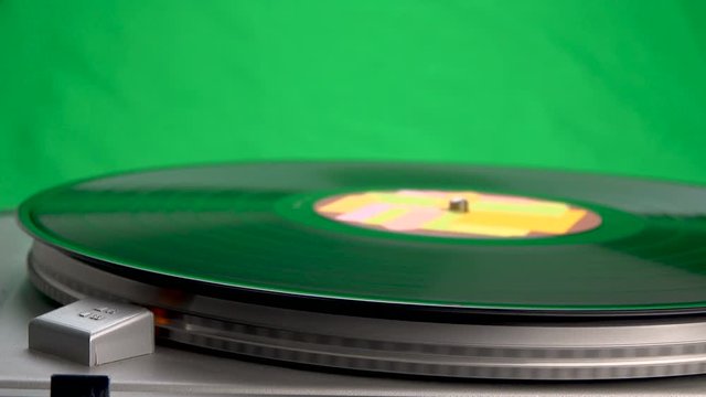 Rotating vinyl player with a plate on a background of green chroma key color.