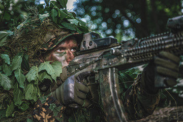 Portrait of a camouflaged soldier in forest during patrol