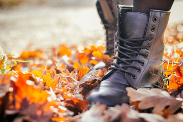 Girl boots on autumn leaves