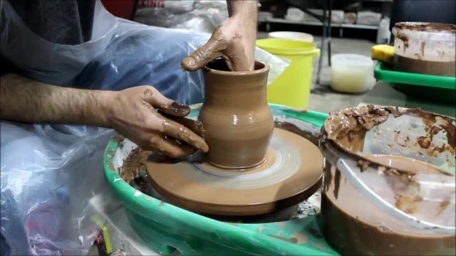 A Bulgarian master with 14 years of experience on a potter's wheel gives shape to the wall of the future pot from the inside and the outside with two hands, making him pot-bellied