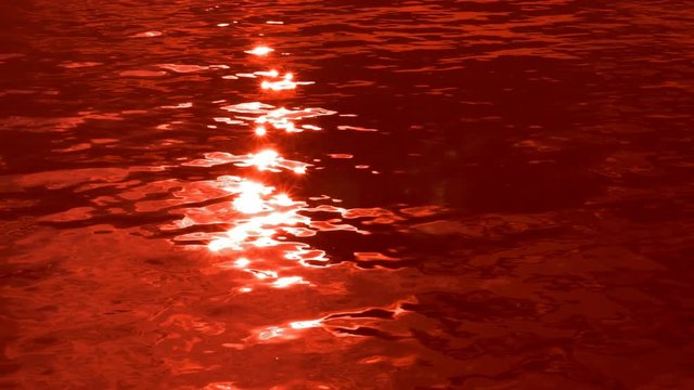 Blood lake. Slow motion lake tinted blood red. Ominous and spooky,
