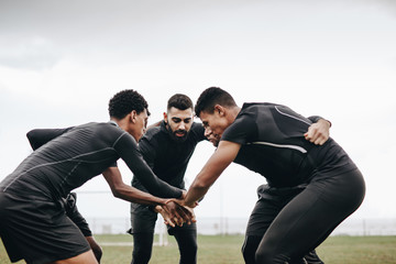 Football players standing in a huddle on the field