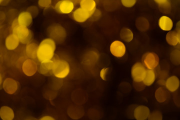 Bokeh. Holiday background. Christmas lights. Glitter. Defocused sparkles. New Year backdrop. Festive wallpaper. Blinks. Carnival. Tinsel. Bokeh retro style photo. Golden. Gold.