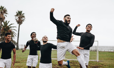 Group of soccer players celebrating victory