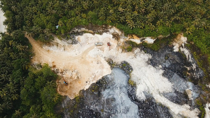 Excavator loads the truck in a limestone quarry. Aerial view wheel loader excavator machine loading...