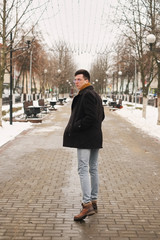 Young man with a urban look in city. hipster man in the city winter