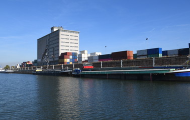 container am hafen mit industrie und fabrikgeb&auml;ude am fluss mit schiff