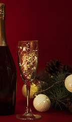 Wineglass with christmas garland on red background.
