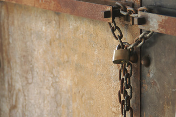 Rusty Chain with Lock on old Metal Double Doors