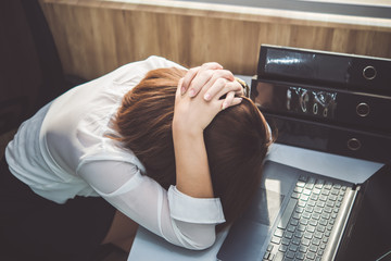 Asian woman working in office,young business woman stressed from work overload with a lot file on...
