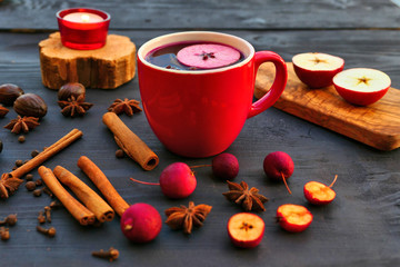Christmas mulled wine with spices and apple in red mug