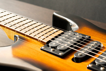 Fragment of the body of an electric guitar with pickups. Signature stamp and strings.