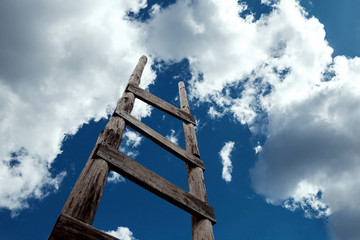 Creative background, wooden staircase leading to the sky. The concept of a career ladder, raising at work, the road to heaven, faith, career growth. Copy space.
