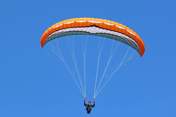 Paraglider flying in a blue sky