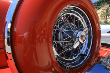 Close up shot of a spare tire on a red retro car