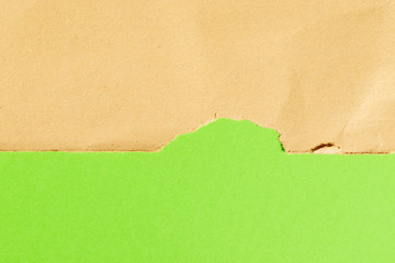torn brown paper on green background with copyspace