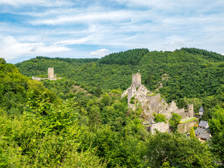 Fototapeta na wymiar Summer panoramic view to the ruins of Oberburg and Niederburg, the Upper and Lower Castle of Manderscheid, Germany as seen from the main street