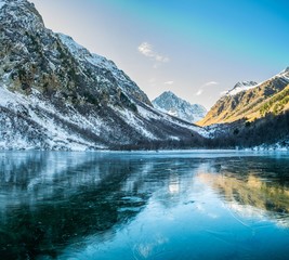 Panoramic landscape, frozen mountain Baduk lake and mountain range with reflection on ice, national park in Caucasus mountains, Russia