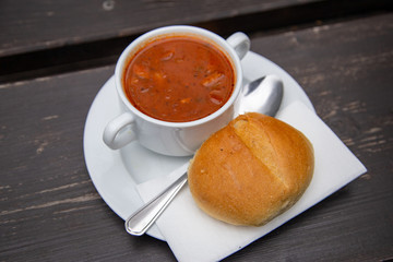 Soljanka with bread roll and spoon