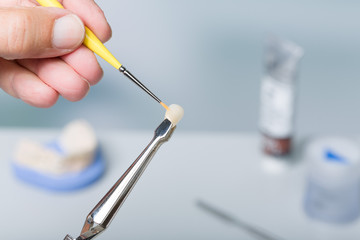 Ein Zahnersatz wird im Dentallabor farblich behandelt