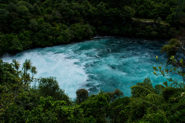 Naklejka na ściany i meble Travel New Zealand. Most popular tourist attraction Huka Falls at Lake Taupo, North Island. White and turquoise water, green forest on background. Beautiful landscape view. Active summer holidays. 