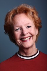 Mature woman with orange hair in front of a colored background