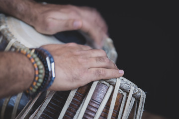 Images of a man's hands (wearing beads) playing the Tabla - Indian classical music percussion...