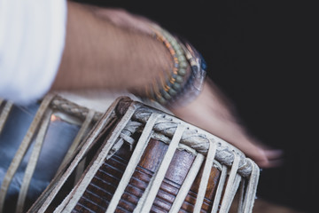 Images of a man's hands (wearing beads) playing the Tabla - Indian classical music percussion...
