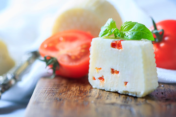 Homemade cheese with tomatoes on a light background. Copy space background.