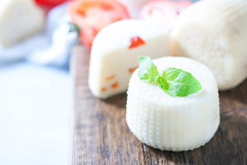 Homemade cheese with herbs on a light background. Copy space background.