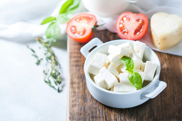 Homemade cheese with herbs on a light background. Copy space background.
