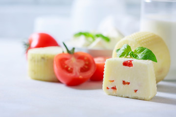 Homemade cheese with tomatoes on a light background. Copy space background.