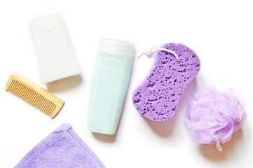 Obraz na płótnie Canvas Flat lay organic bath products. Top view photo shampoo, shower gel, purple sponge, hair brush and towel