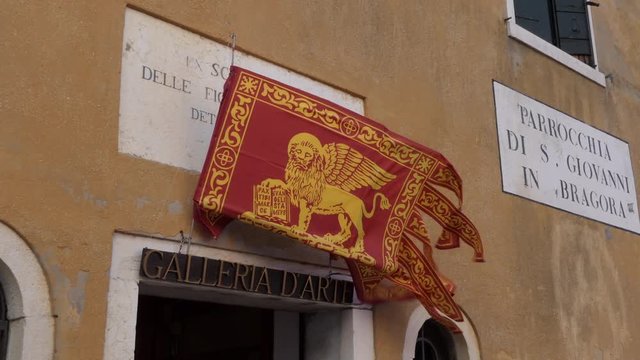View of the historic Venetian flag in Venice, Italy. Symbol of the old Republic of Venice in Venezia, Italia