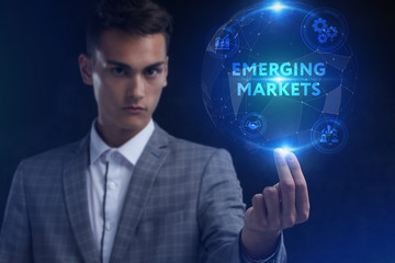 The concept of business, technology, the Internet and the network. A young entrepreneur working on a virtual screen of the future and sees the inscription: Emerging markets