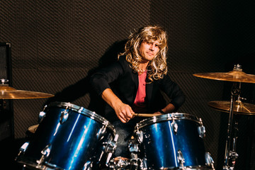 Fototapeta na wymiar Male drummer wearing a blonde wig