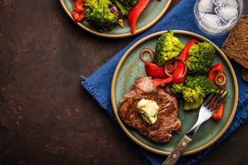 Grilled Beef steak with garlic butter and vegetables. Meat with grilled bell pepper, broccoli and onions.