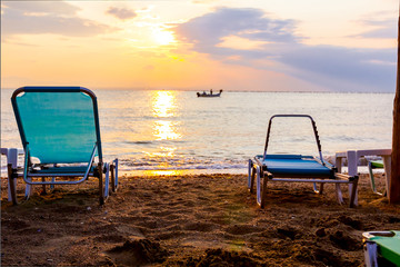 Morning Sun over sea, dawn, deck chairs are placed next to the coastline