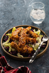 Salad with warm glazing chicken, sprinkled with sesame seeds. Chinese cuisine. Asian culture