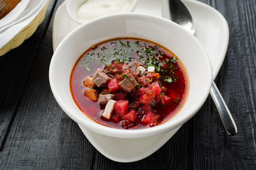 Homemade borsch with meat and sour cream.