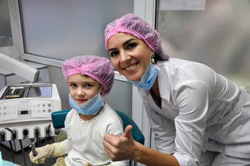 little girl and dentist doctor smile after dental treatment procedure.