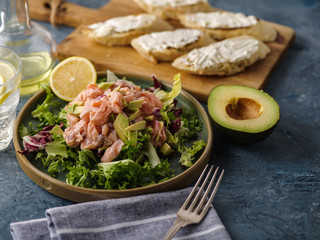 Ceviche is a traditional dish from Peru. Salmon marinated in lemon with fresh lettuce, avocado and onions