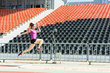 Young girl in the stadium jumping.