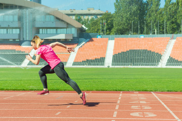 A young girl in the stadium runs.