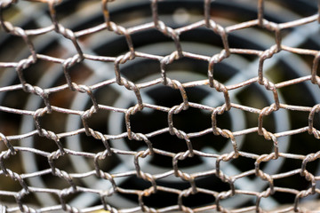 Closeup photo of a metal netting on the background of the sewer lattice     