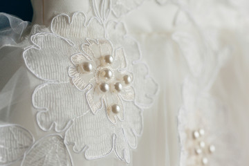 Detail of an elegant white wedding dress