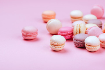 Different types of macaroons on pink background. Sweet and colourful french macaroons.